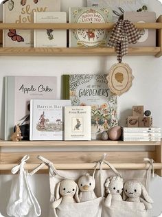 two stuffed animals sitting on top of a wooden shelf next to books and other items