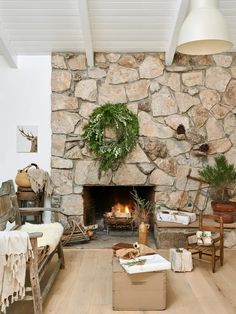 a living room filled with furniture and a fire place in the middle of a stone wall