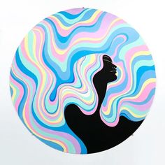 a woman's face is painted in multicolored swirls on a circular plate