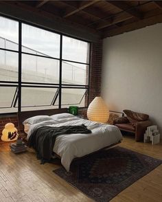 a bedroom with large windows and a bed