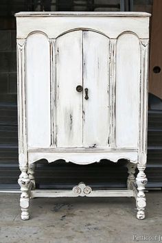 an old white cabinet is sitting outside