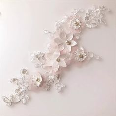 the wall is decorated with white flowers and pearls