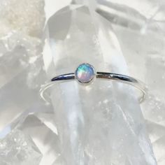 a white opalite ring sitting on top of ice crystals