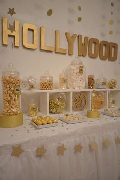 the dessert table is set up with gold foil stars and hollywood sign on it's wall