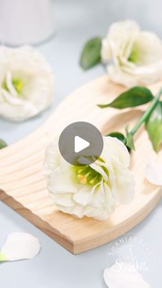 white flowers sitting on top of a wooden cutting board