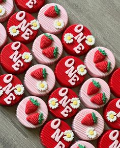 red and white cupcakes with strawberries on them are arranged in the shape of hearts