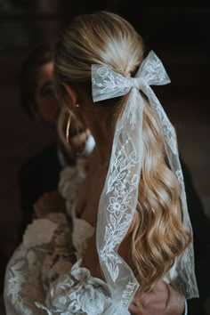 a woman wearing a veil with a bow in her hair