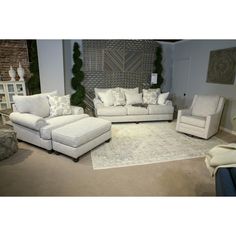 a living room filled with white furniture and pillows on top of it's carpet