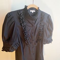 Perfect Condition, Never Worn! Black Short Sleeve Button Down With Beautiful Ruffle Detail On The Neck, Chest And Sleeves. The Piece Has A Flattering Cut That Is Tailored In At The Waist. Can Easily Be Worn Out For A Finished Look, Does Not Have To Be Tucked In. Buttons Are Covered In Identical Fabric To The Blouse. 65% Cotton, 30% Nylon, 5% Spandex. Black Ruffle, Black Shorts, Button Downs, Button Down Shirt, Conditioner, Womens Tops, Women Shopping, Fabric, Black