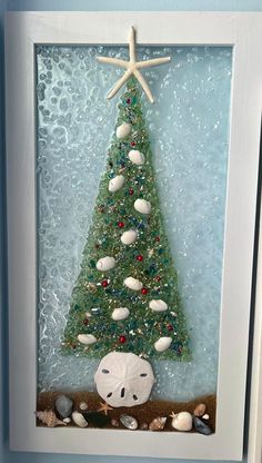 a christmas tree made out of sea glass with shells and starfish on the bottom