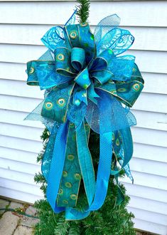 a blue and green bow on top of a tree