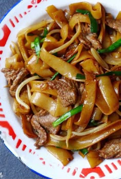 a white plate topped with noodles and meat