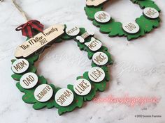 two christmas wreath ornaments with names on them