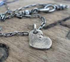 "Heart on a String" My organic fine silver heart charm floats freely on a string of elongated cable chain..COMPONENTS:~12mm recycled fine silver (99% pure silver/ sterling is 92.5% silver) heart charm that I have constructed entirely by hand so it's completely unique! Size is approximate since these are made one at a time.Sterling silver elongated cable chain. All metal components are high quality sterling and fine silver that I have oxidized, brushed and carefully polished by hand to add a bit Rustic Hearts, Mountain Fashion, Silver Heart Jewelry, J Design, Heart Aesthetic, String Necklace, Crystal Rainbow, Earthy Style, Cleaning Silver Jewelry