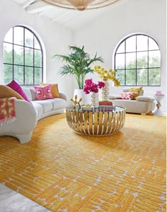 a living room filled with lots of furniture and large round windowed windows in the wall