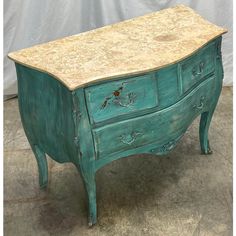 an old green dresser with marble top