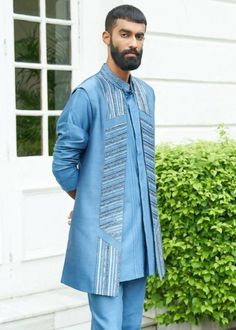 A shrug set made on silk blend fabric, having detailing creating a linear statement throughout the placket. Designer Blue Kurta With Cutdana, Designer Blue Nehru Jacket, Designer Blue Cutdana Sets, Designer Blue Nehru Jacket With Traditional Drape, Designer Blue Nehru Jacket For Eid, Blue Cotton Silk Sets With Traditional Drape, Designer Blue Bandhgala With Traditional Drape, Fitted Blue Cotton Silk Set, Blue Cotton Silk Long Sleeve Sherwani