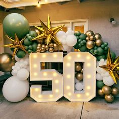 the number 50 is surrounded by balloons and starbursts in gold, white and green