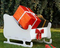 a sleigh with presents on it sitting in the grass