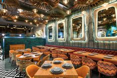 the interior of a restaurant with wooden tables and orange chairs