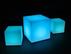 three illuminated cubes on a black background