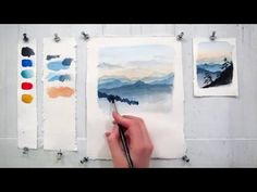 someone is painting on paper with watercolors