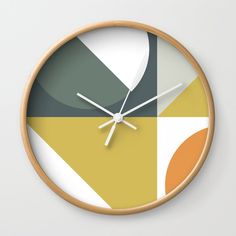 a clock that is on the side of a wall with different colors and shapes around it