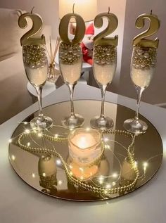 three champagne flutes are sitting on a table with the number twenty two in front of them