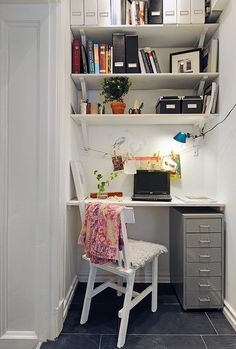 a computer desk sitting in front of a bookshelf