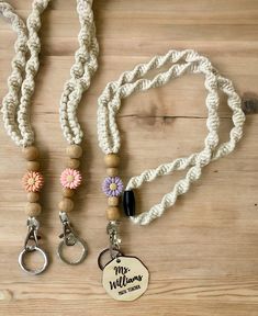 two lanyards with personalized charms and keychains on a wooden surface