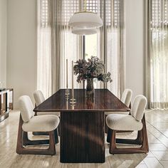 a dining room table with white chairs around it