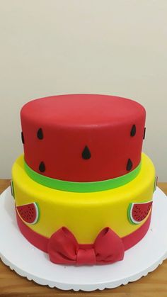 three tiered cake decorated with watermelon and polka dot design on white plate