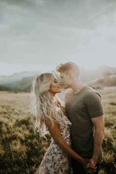 a man and woman are standing in the grass