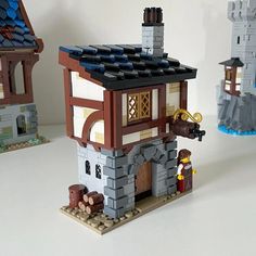 some legos are sitting on a table and there is a small house made out of bricks