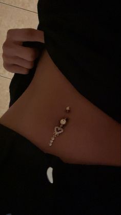 a woman's stomach with a gold and diamond bracelet on her left side, in front of a tile floor