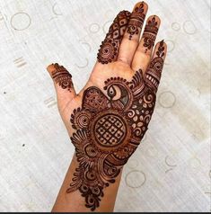 a hand with henna on it that is showing the intricate designs and patterns around it