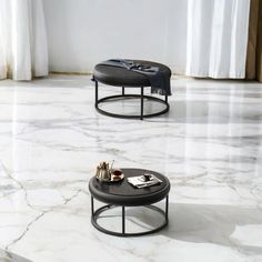 two black tables sitting on top of a white marble floor