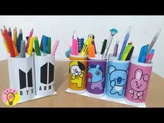 some pens and pencils are in cups on a table