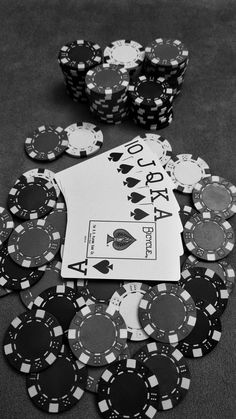 poker chips and cards on the table with one playing card in black and white photo