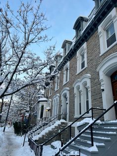 a row of houses with snow on the ground and stairs leading up to them in winter