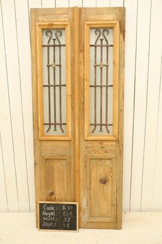 an old pair of wooden doors with wrought iron windows