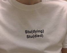 a person wearing a white t - shirt with the words studying studded on it