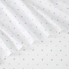 a white bed with blue polka dots on it