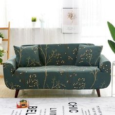 a green couch sitting on top of a hard wood floor next to a white wall