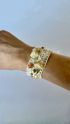 a woman's arm with a bracelet made out of beads and crochet