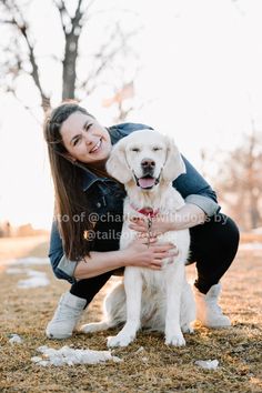 a woman is hugging her dog in the park