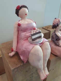 two mannequins dressed in pink sitting next to each other on wooden blocks