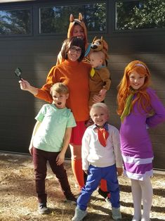 a group of people in costumes posing for a photo outside with one person holding a cell phone