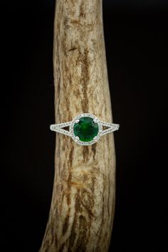 Product Details Ring Style:The "Aura" is a birthstone ring with a split shank-style & lab-created emerald women's ring with delicate and ornate details and is available with many center stone options Center Stone:7mm Round Lab-createdEmerald Materials: 14K gold engagement ring featuring a lab-created emerald center stone and a 1/5 ctw diamond halo and accents. Customizable:Because each of our rings is handcrafted to order, wecan customize yours using unique materials, gemstones, or design fe Classic Halo Jewelry For May Birthstone, Heirloom Style May Birthstone Jewelry For Promise, Heirloom Style Emerald Ring With Halo, Heirloom Emerald Ring With Halo, May Birthstone Halo Jewelry For Formal Occasions, Green Cluster Ring With Halo, Formal Halo Jewelry For May Birthstone, Fine Jewelry Tsavorite Birthstone Ring, Halo Promise Ring With May Birthstone