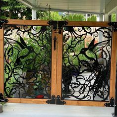 an iron and wood gate with birds on it